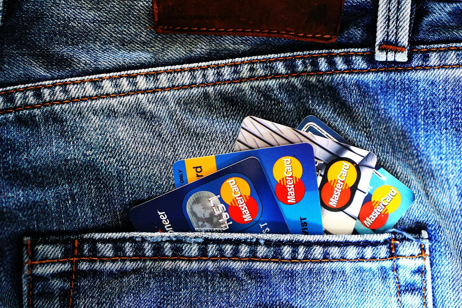 Close-up of a denim pocket with multiple credit cards, illustrating finance and fashion.